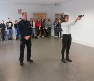 Policyjny Instruktor Strzelań prowadzi zajęcia na trenażerze strzeleckim dla laureatów turnieju &quot;Młody Ratownik&quot;.