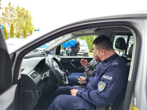 policjant prezentuje osobie radiowóz